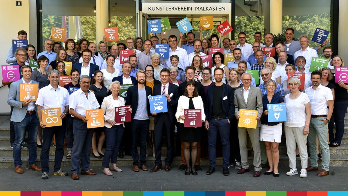 Eine Gruppe von Menschen mit SDG-Schildern
