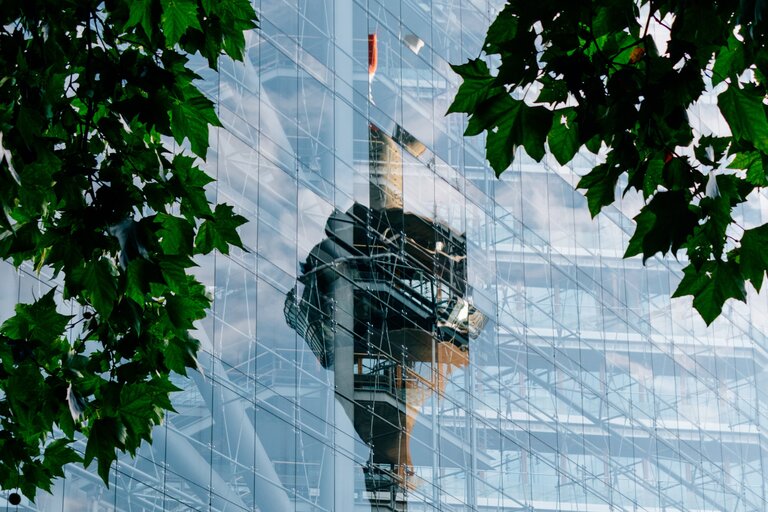 Der Düsseldorfer Fernsehturm spiegelt sich in der Glasfassade des benachbarten Stadttores