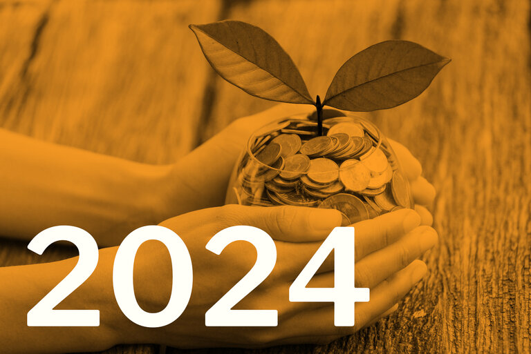Die Zahl 2024, im Hintergrund eine Pflanze, die aus einem Glas mit Münzen wächst