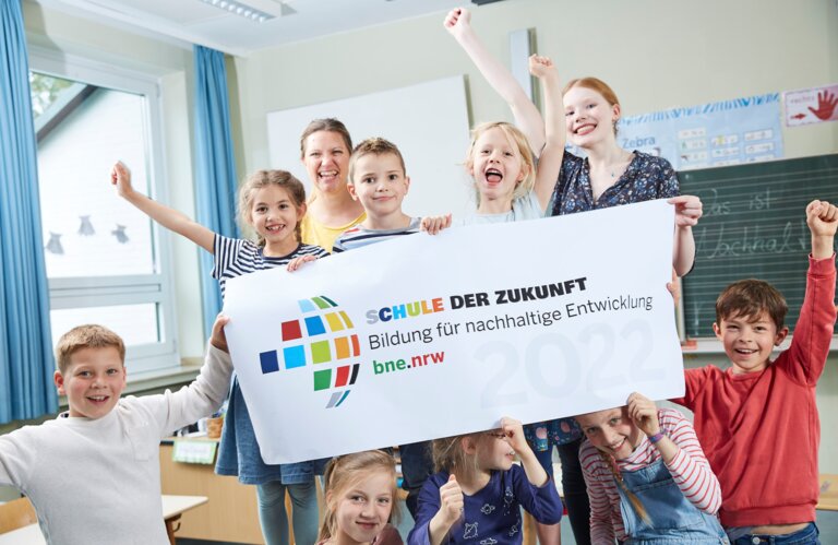 Kinder mit einem Plakat von "Schule der Zukunft“